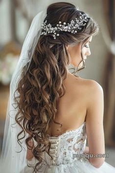 a woman wearing a wedding veil with flowers in her hair