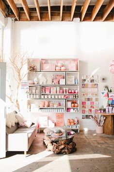 a living room filled with furniture and lots of pink decorations on the wall above it