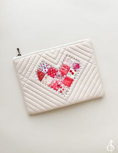 a white purse with patchwork heart on it