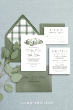 the wedding stationery is displayed on top of an envelope, with greenery in front