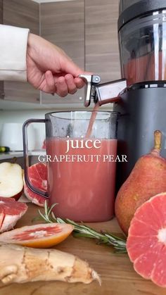 a person is using a juicer to make grapefruit pear smoothie in the kitchen