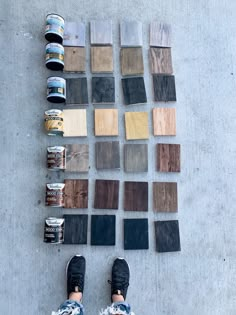 someone standing on the floor with their feet up next to some paint and wood samples