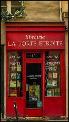 a red store front with many books on the windows and doors, in paris's rue la porte etroite