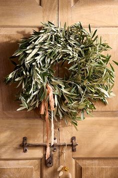 an olive wreath hangs on the front door