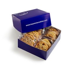 a blue box filled with cookies sitting on top of a white table next to a purple container