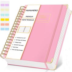 a pink spiral notebook sitting on top of a white table