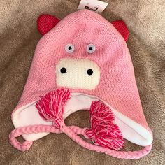 a pink hat with a cow face on it