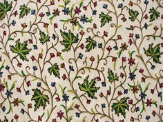 an intricately designed wallpaper with flowers and leaves on it's surface,