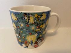 a coffee cup decorated with cartoon characters on it's sides and gold chains around the edges