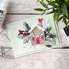 a close up of a christmas card on a table with some flowers and scissors next to it