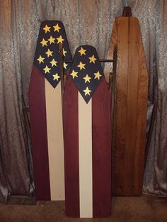 two wooden sleds with stars on them sitting in front of a curtain covered wall