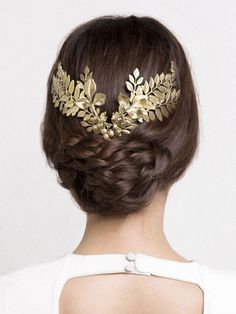 a woman wearing a gold hair comb with leaves on it