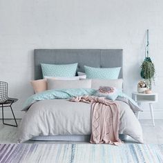 an image of a bedroom with blue and white decor on the walls, bedding and pillows