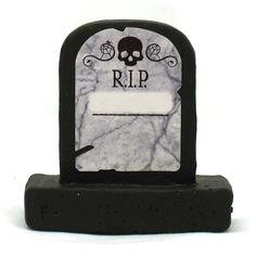 a black and white tombstone with a skull on it's head, sitting in front of a white background