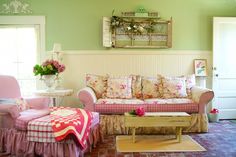 a living room filled with furniture and flowers on the table in front of a window