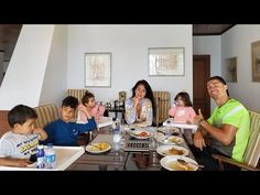 a group of people sitting around a table with plates of food in front of them