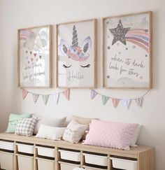 three framed pictures hang on the wall above a bench with storage bins underneath it