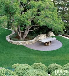 a bench sitting on top of a lush green field next to a stone wall and tree