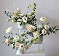 white flowers are arranged in vases on a table