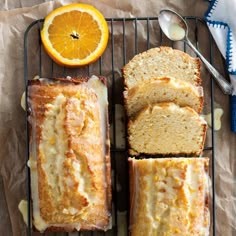 slices of orange pound cake sitting on top of a cooling rack next to sliced oranges