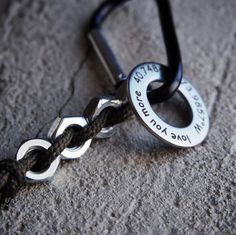 a close up of a black and silver key on a stone surface with a rope attached to it