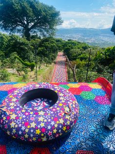 a person standing on top of a colorful blanket next to an inflatable object