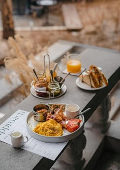 a table topped with plates of food next to a cup of coffee and orange juice