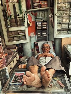 an old man sitting in a chair with his feet propped up on the table next to him