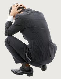 a man sitting on the ground with his head in his hands