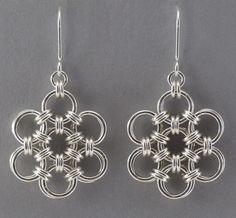 the earrings are made from silver wire and have an intricate design on each earring