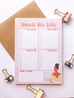 the small biz life planner is next to some paper clips