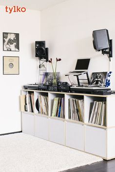 there is a record player on top of the shelf in this room with other records