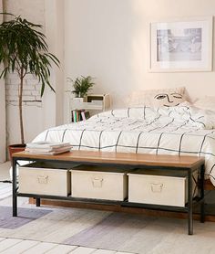 a bed with white sheets and two drawers under the headboard is in a bedroom