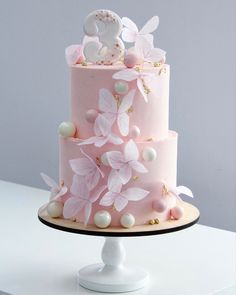 a three tiered cake with pink and white decorations