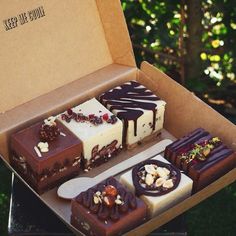 a box filled with lots of different types of desserts on top of a table