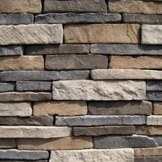 a stone wall made out of several different types of stones, including gray and brown