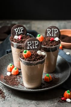 three cups filled with dirt and candy on top of a plate