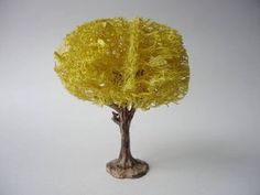 a small yellow tree sitting on top of a white table