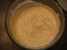 a bowl filled with batter sitting on top of a wooden table