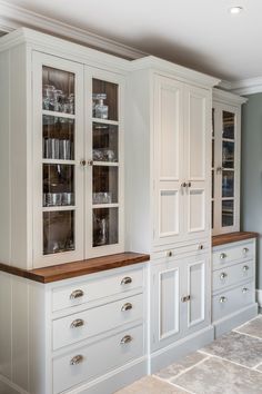 a kitchen with white cabinets and wooden counter tops