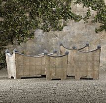 three birds are perched on the back of four wooden benches in front of a stone wall