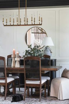 a dining room table with chairs and a cat laying on the floor