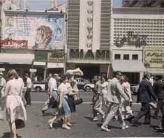 an old photo of people walking in the street