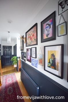 a hallway with pictures on the wall and rug