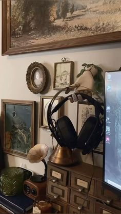 a computer monitor sitting on top of a wooden desk next to a bunch of pictures