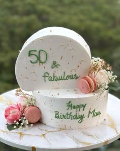 two birthday cakes sitting on top of a cake platter with flowers and the words 50 and fabulous