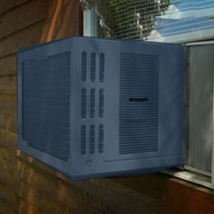 an air conditioner mounted to the side of a house next to a window sill