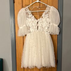 a white dress hanging on a wooden door