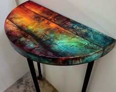 a wooden table sitting on top of a tile floor next to a white wall in a room