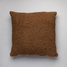 a brown pillow on a white surface with no one in the photo to describe it